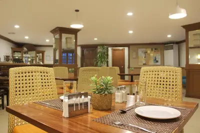 a dining room with a wooden table and chairs at Rothman Hotel in Manila