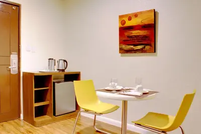 a table and chairs with a table and a painting on the wall at Rothman Hotel in Manila
