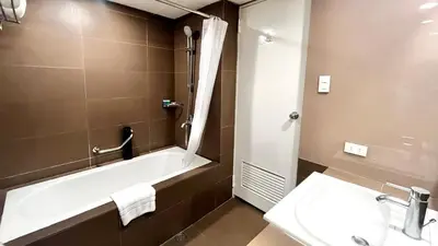 a bathroom with a bath tub and a sink at Riviera Mansion Hotel in Manila