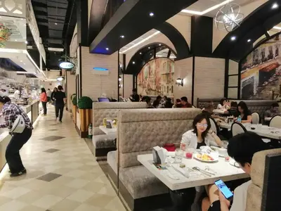 a group of people sitting at tables in a restaurant at SNAPz Staycation @ Jazz Residences in Manila