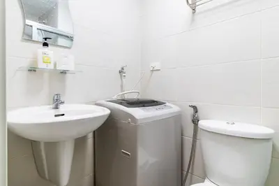 a white bathroom with a sink and a toilet at SNAPz Staycation @ Jazz Residences in Manila