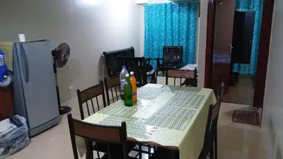 a kitchen with a table with chairs and a refrigerator at Mmr in Manila