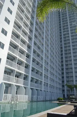 an apartment building with a pool in front of it at Jovic's Condo at Breeze Residences. in Manila