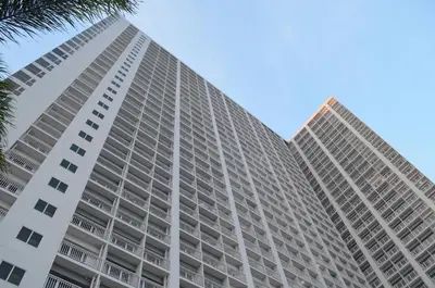 a tall apartment building with a blue sky in the background at Jovic's Condo at Breeze Residences. in Manila