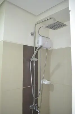 a shower with a shower head in a bathroom at Jovic's Condo at Breeze Residences. in Manila