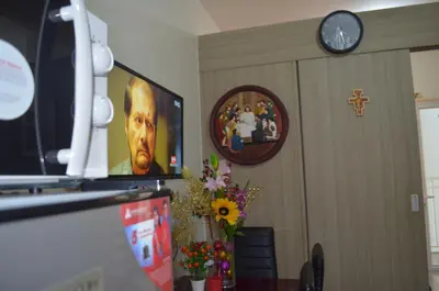 a room with a clock and a picture of a man at Jovic's Condo at Breeze Residences. in Manila