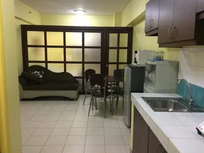 a kitchen with a couch and a table with chairs at Leons Den is a long term accomodation of atleast 1 month stay in Manila