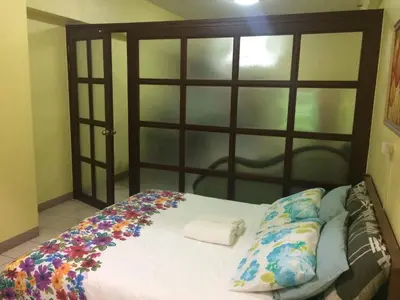 a bed with a wooden headboard with flowers on it at Leons Den is a long term accomodation of atleast 1 month stay in Manila