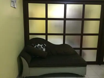 a couch sitting in front of a window at Leons Den is a long term accomodation of atleast 1 month stay in Manila