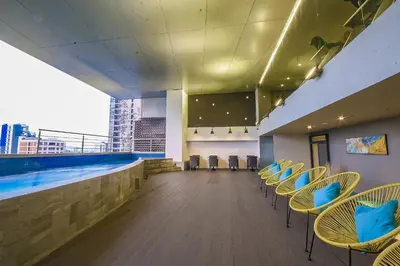 a swimming pool with chairs and a swimming pool at Skyloft Hotel in Manila