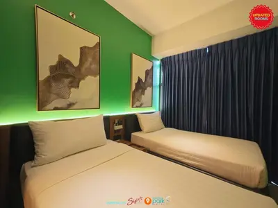 two beds in a room with green walls at Skyloft Hotel in Manila
