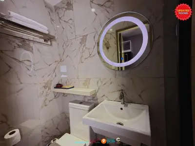 a bathroom with a sink and a mirror at Skyloft Hotel in Manila