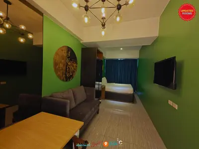 a living room with green walls and a couch at Skyloft Hotel in Manila
