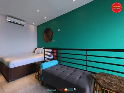 a bedroom with a bed and a couch in it at Skyloft Hotel in Manila