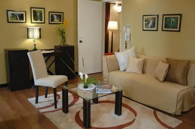 a living room with a couch and a table and a chair at Manila Manor Hotel in Manila