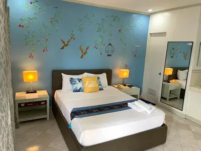a bedroom with two beds and a blue wall at Riverview Resort and Conference Center in Calamba