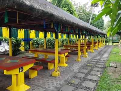 a row of picnic tables with a thatched roof at Riverview Resort and Conference Center in Calamba