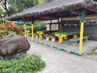 a group of benches sitting under a pavilion at Riverview Resort and Conference Center in Calamba