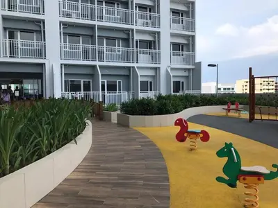 a building with two children riding skateboards on a sidewalk at SMDC Breeze Residences by Dominga in Manila