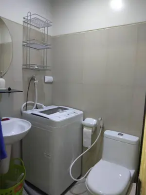 a white bathroom with a toilet and a sink at SMDC Breeze Residences by Dominga in Manila