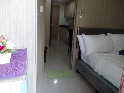 a bedroom with a bed and a table with flowers on it at SMDC Breeze Residences by Dominga in Manila