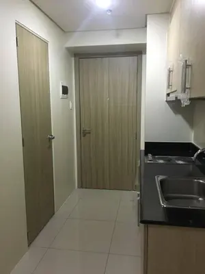 a kitchen with a door and a sink and a counter at SMDC Breeze Residences by Dominga in Manila