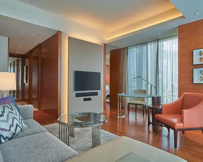 a living room with a couch and a tv and a table at Grand Hyatt Manila in Manila