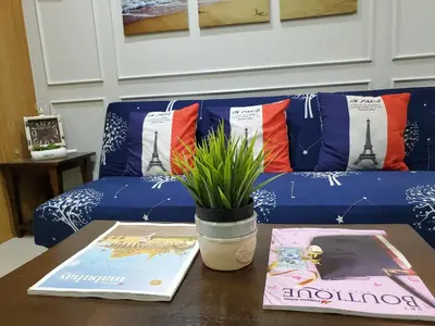 a table with a couch with a book and a potted plant at Shell Residence Manila in Manila