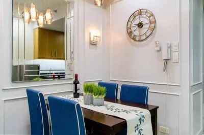 a dining room with a table and blue chairs at Shell Residence Manila in Manila