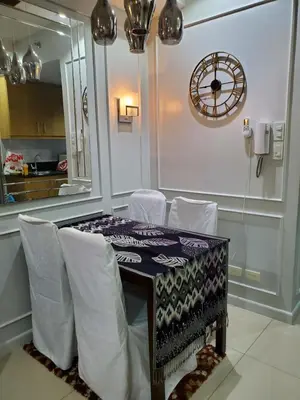 a dining room with a table and white chairs at Shell Residence Manila in Manila