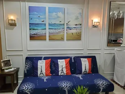 a blue couch in a living room with three paintings at Shell Residence Manila in Manila