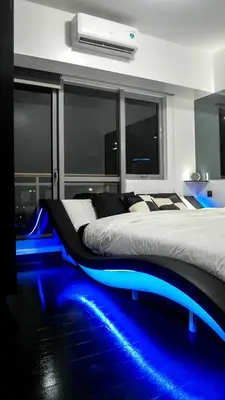 a bedroom with a bed with blue lights on the floor at Modern Luxury Lower Penthouse Unit in Manila