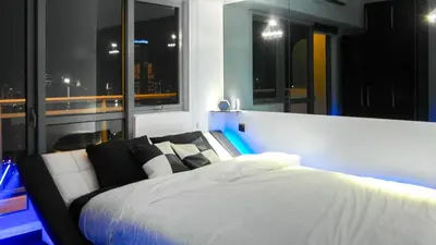 a bedroom with a white bed and windows at Modern Luxury Lower Penthouse Unit in Manila