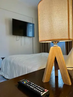 a lamp sitting on a table next to a remote control at East Ortigas Mansions by MA in Manila