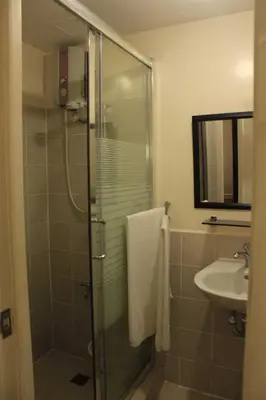 a bathroom with a shower and a sink at East Ortigas Mansions by MA in Manila