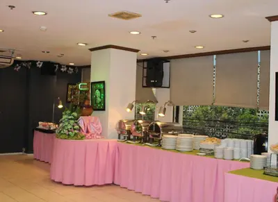 a buffet line with pink tables and plates at Rosas Garden Hotel in Manila