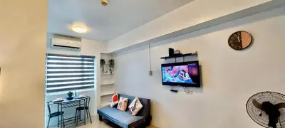 a living room with a flat screen tv on the wall at De Luxe, Standard and Studio Suites -The Breeze Residences-close to Airport,Mall of Asia, US Embassy in Manila