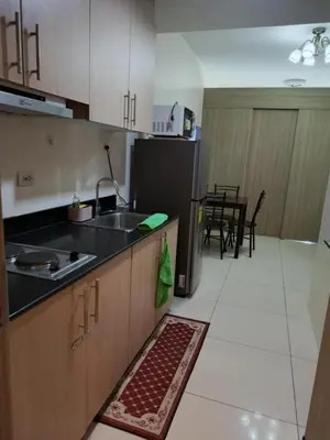 a kitchen with a sink and a refrigerator at De Luxe, Standard and Studio Suites -The Breeze Residences-close to Airport,Mall of Asia, US Embassy in Manila