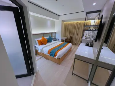 a bedroom with a bed with colorful pillows and a ladder at City Garden Hotel Makati in Manila