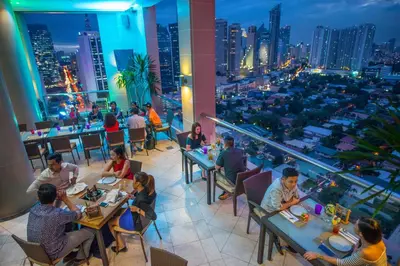 a group of people sitting at tables in a restaurant at City Garden Hotel Makati in Manila