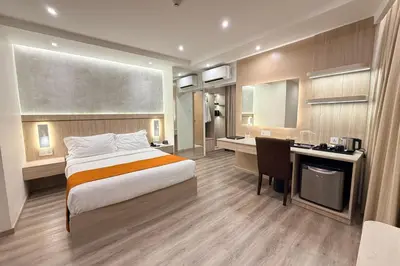 a hotel room with a bed and a desk at City Garden Hotel Makati in Manila