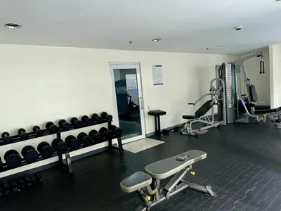 a gym with dumbbells and machines in a room at JR Studio Luxe 1824 at Princeton Residences in Manila