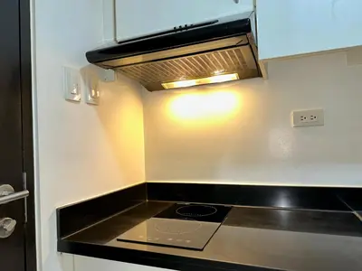 a stove top oven in a kitchen with a light at JR Studio Luxe 1824 at Princeton Residences in Manila