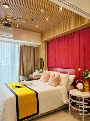 a bedroom with a large bed with a red headboard at Holiday Escape Philippines in Manila