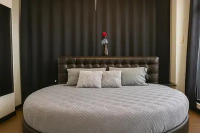 a large bed with a brown headboard and two pillows at 2-story Penthouse with 5 Balconies in Manila