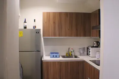 a small kitchen with a refrigerator and a sink at 2-story Penthouse with 5 Balconies in Manila
