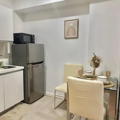 a small kitchen with a table and a refrigerator at AZURE URBAN RESIDENCES- Beach View in Manila