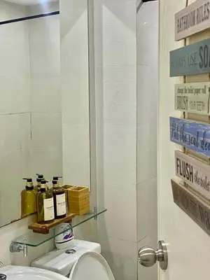 a bathroom with a toilet and a mirror at AZURE URBAN RESIDENCES- Beach View in Manila
