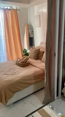 a bed in a bedroom with an orange curtain at AZURE URBAN RESIDENCES- Beach View in Manila