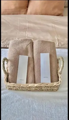 a basket filled with towels on a bed at AZURE URBAN RESIDENCES- Beach View in Manila